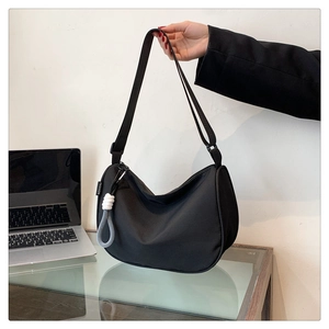 Detail of black nylon hobo bag showing the fashion label and decorative zipper knot