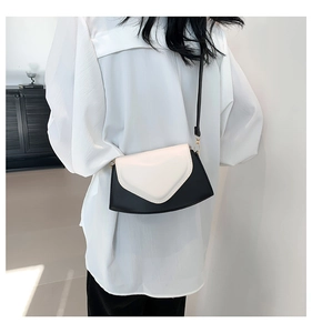 Détail du sac bandoulière bicolore noir et blanc avec finitions métalliques dorées