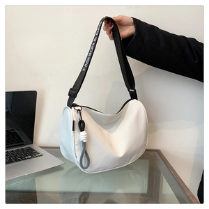 Close-up of a white crescent shoulder bag with 'FASHION & BAG' text on black strap