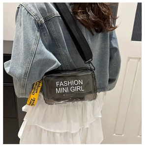 Close-up of translucent grey jelly crossbody bag with fashion print and yellow woven tag