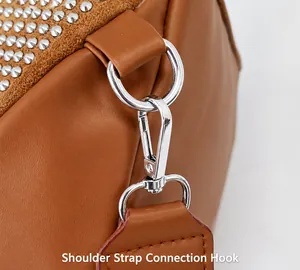 Détail d'un sac en cuir caramel avec anneau en D argenté et fermoir mousqueton en métal