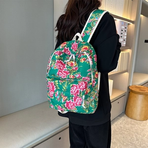 Detail of floral canvas backpack featuring traditional Chinese peony pattern and white handles