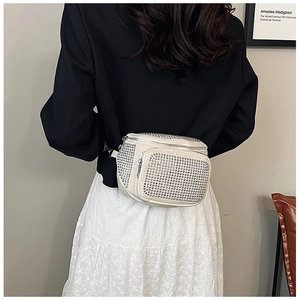 Détail du sac à bandoulière crème avec strass argentés et sangle réglable en tissu noir