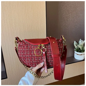 Detailed view of red tweed dumpling bag with gold chain strap and smooth leather trim