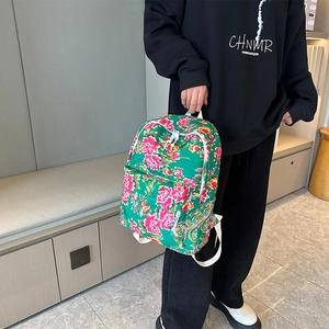 Detail view of ethnic green floral backpack with pink peonies and white straps