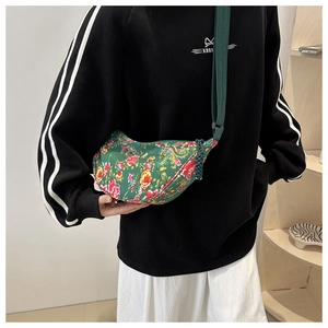 Detail of floral canvas crescent crossbody bag with ethnic peony pattern and green strap