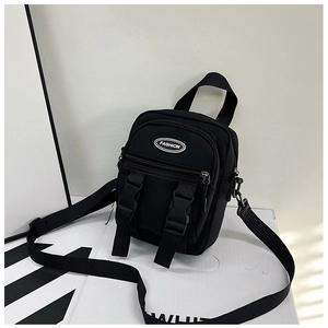 Detail van de waterdichte nylon crossbodytas met fashionlabel en verstelbare riem