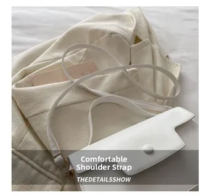 Close-up of comfortable shoulder strap and hardware detail on a white crossbody handbag