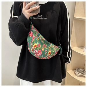 Detail of green floral crossbody bag with vibrant peony pattern and durable zipper