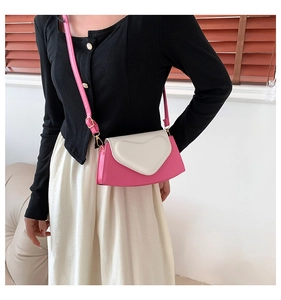 Détail du petit sac bandoulière rose et blanc avec rabat cœur en 3D et boucles métalliques