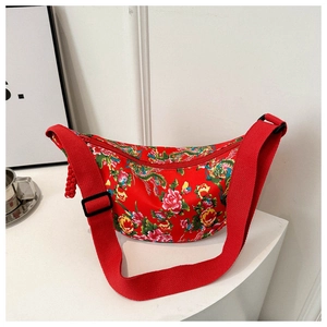 Detail of red floral crescent crossbody bag featuring peony and dragon patterns