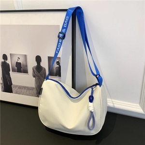 Minimalist cream saddle bag with blue contrast straps and white logo print