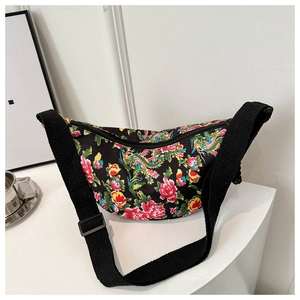 Detail of floral dragon and phoenix pattern on black canvas crossbody bag