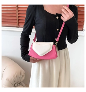 Détail du mini sac à bandoulière en cuir rose avec rabat coeur 3D blanc et finitions dorées