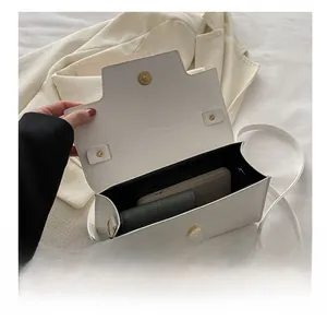 Interior view of white leather crossbody bag showing capacity for phone and wallet
