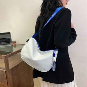 White nylon shoulder bag with fashion blue strap shown on model in modern office