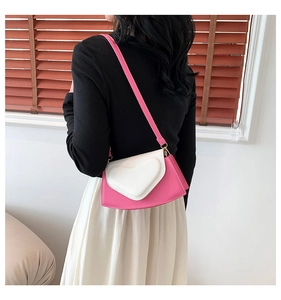 Détail du sac à bandoulière rose et blanc avec rabat en forme de cœur 3D et boucles dorées