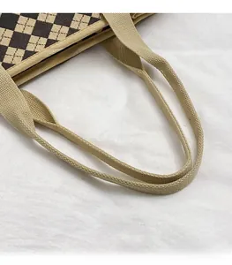 Dettaglio dei manici in tessuto resistente e del motivo trapuntato di una borsa shopper