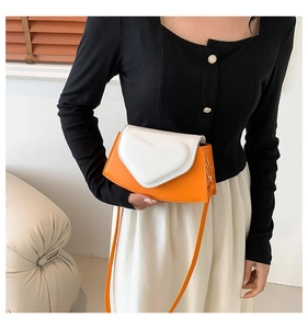 Détail du sac bandoulière avec design patchwork orange et blanc et cœur texturé