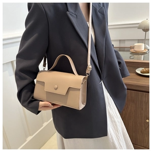 Chic beige crossbody square bag for women worn with a gray suit in a café setting