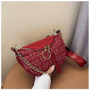 Detail of red tweed saddle bag with gold chain strap and large ring zipper puller