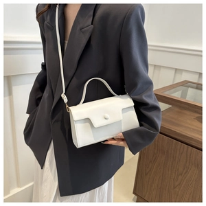 Minimalist white leather crossbody bag detail with a top handle and matching shoulder strap