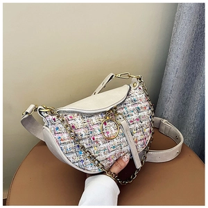 Detail view of tweed patchwork dumpling bag with golden chain and round zipper puller
