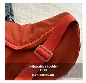 Detail view of the adjustable shoulder strap on the red nylon crossbody bag