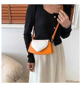 Détail d'un sac bandoulière chic en forme de cœur en similicuir orange et blanc contrasté