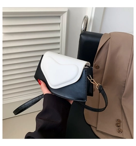 Détail du petit sac à bandoulière cœur contrasté avec base au design irrégulier
