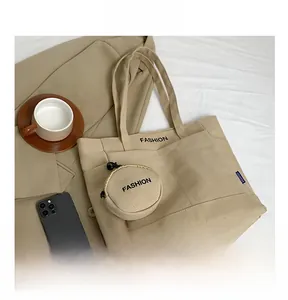 Detail of canvas tote bag with fashion print and matching round coin purse on fabric