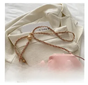 Détail du sac seau plissé rose avec boucle boule dorée ajustable et bandoulière