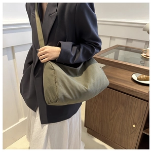 Detail shot of olive green canvas slouchy crossbody bag with adjustable wide strap