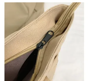 Detailed close-up of a durable metal zipper closure on a beige canvas tote bag