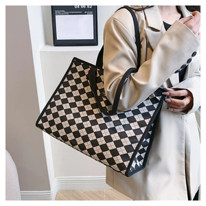 Vista laterale dettagliata della borsa tote a scacchi capiente indossata da modella