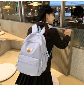 Dettaglio di uno zaino in nylon viola chiaro con pratiche tasche laterali dotate di coulisse
