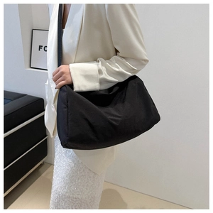 Large black minimalist crossbody bag shown on model for daily style and utility