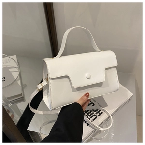 Macro detail of the white faux leather small square bag with geometric flap and round clasp