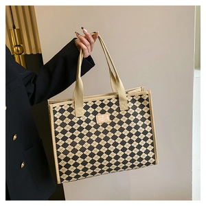 Dettaglio della borsa tote a scacchi con toppa in pelle e lo slogan LOVE YOU HAPPY