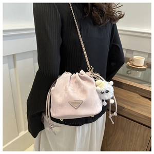 Détail du sac seau lavande avec chaîne dorée et breloque en peluche blanche douce