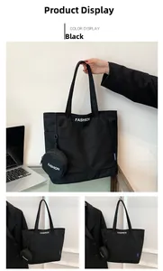 Detail of a large black canvas tote bag with white FASHION text and a small round pouch