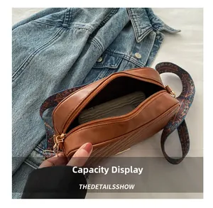 Detailed interior of brown PU leather crossbody bag showing daily capacity on denim cloth