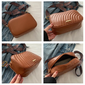 Detailed view of brown quilted crossbody bag with stylish ethnic embroidered wide strap