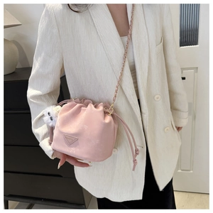 Vue détaillée du sac seau rose avec bandoulière chaîne et breloque en peluche blanche