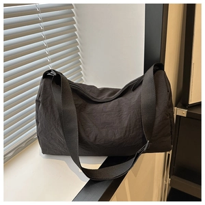 Detailed view of large black nylon crossbody bag with zipper and wide strap