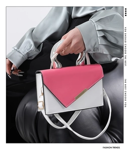 Detail of hot pink and white crossbody bag with silver handle and gold trim finish