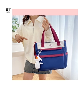 Detailed view of the multi-color tote bag with a plush duck charm and smile logo icon