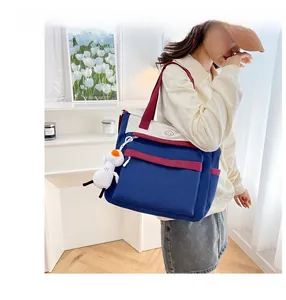 Detail view of large capacity color-block tote bag with cute plush animal charm