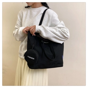 Detail of black canvas tote bag with fashion print and matching round mini pouch