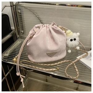 Détail du sac seau lavande avec bandoulière en chaîne et breloque en peluche blanche